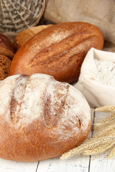 Roggebrood met bloem op tafel op rouwgewaad achtergrond — Stockfoto