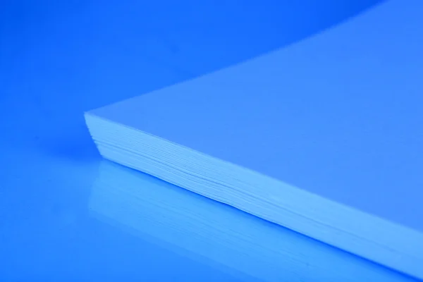 Weißes Papier in Großaufnahme in blauem Licht stapeln — Stockfoto
