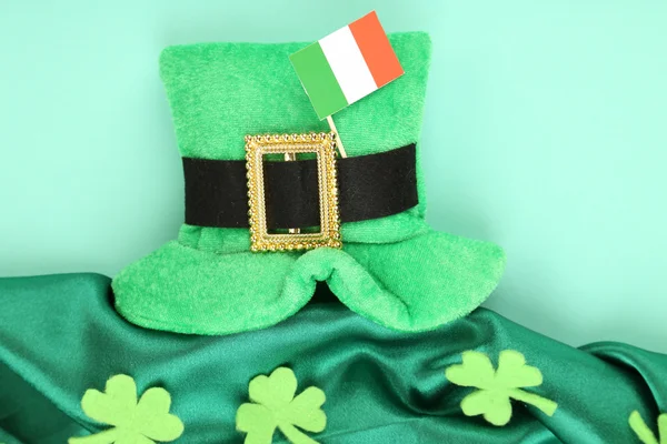 День святого Патрика шляпа с листьями клевера и ирландский флаг на зеленом фоне — стоковое фото