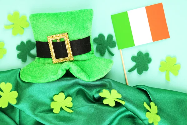 Sombrero de día San Patricio con hojas de trébol y bandera irlandesa sobre fondo verde —  Fotos de Stock