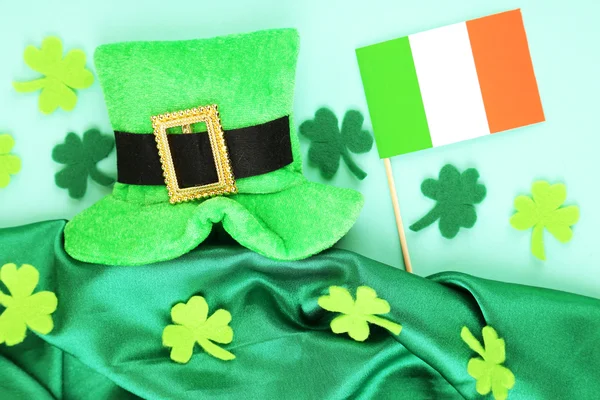 Saint patrick dzień kapelusz koniczyna liść i irlandzkie flagi na zielonym tle — Zdjęcie stockowe