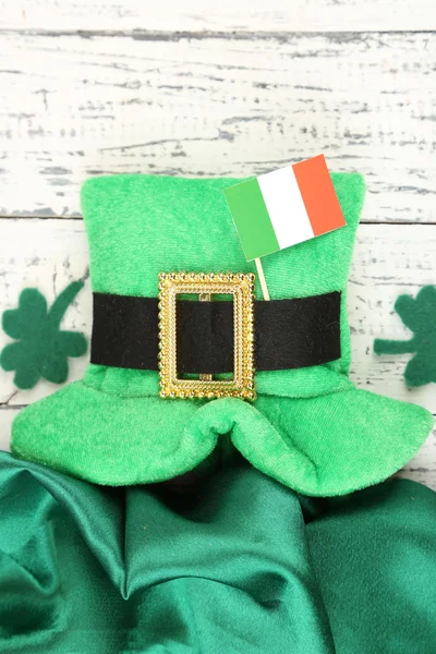 Saint Patrick day hat with clover leaves and Irish flag on wooden background — Stock Photo, Image