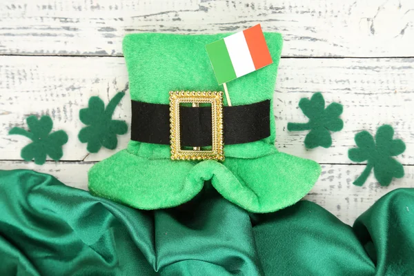 Шляпа дня Святого Патрика с листьями клевера и ирландским флагом на деревянном фоне — стоковое фото