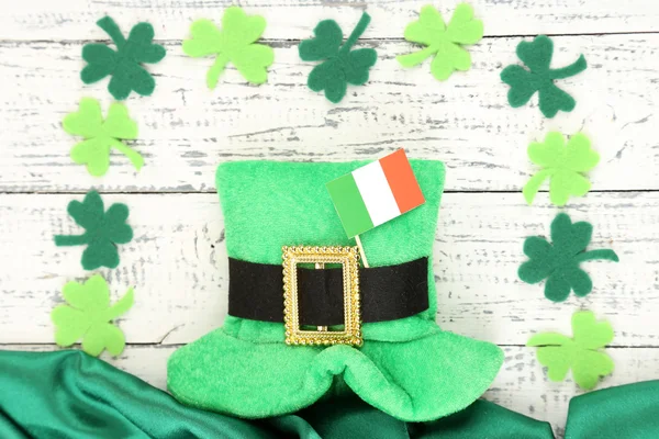 Saint Patrick day hat with clover leaves and Irish flag on wooden background — Stock Photo, Image