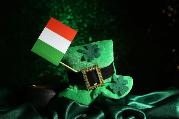 Шляпа Святого Патрика день, горшок золотых монет и ирландский флаг на зеленом блестящем фоне — стоковое фото