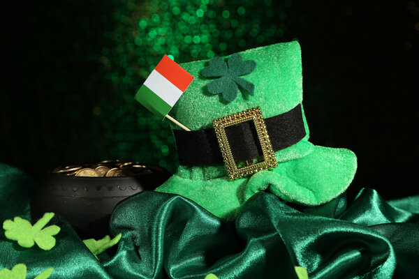 Шляпа Святого Патрика день, горшок золотых монет и ирландский флаг на зеленом блестящем фоне
