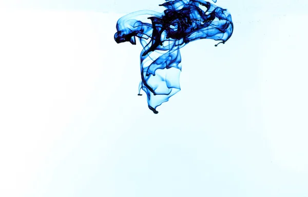 Чернила в воде на синем фоне — стоковое фото