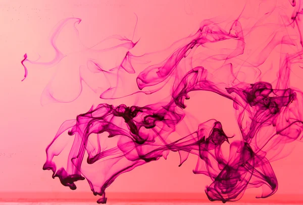 Inkt in water op roze achtergrond — Stockfoto