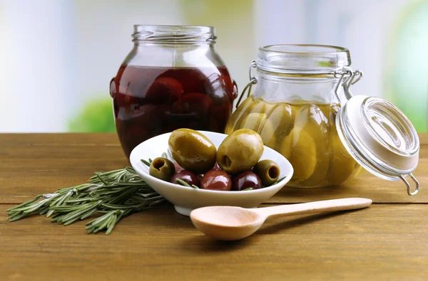 Olive saporite su tavola di legno, su sfondo naturale — Foto Stock