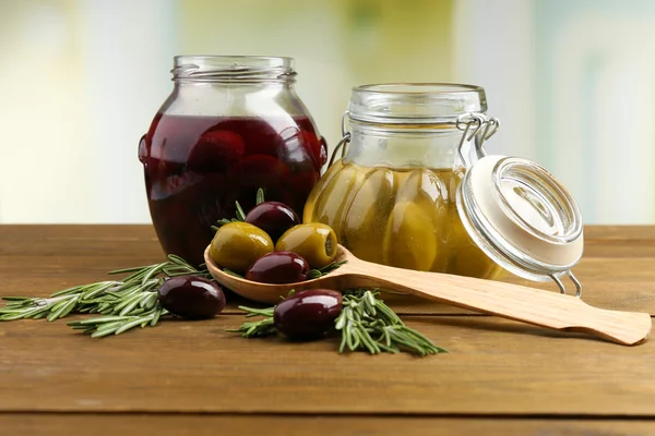 Olive saporite su tavola di legno, su sfondo naturale — Foto Stock