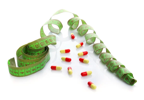 Measuring tape and pills, isolated on white. Dieting concept — Stock Photo, Image