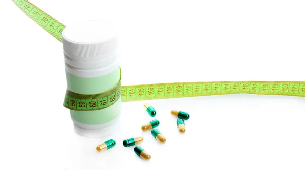 Measuring tape and pills, isolated on white. Dieting concept — Stock Photo, Image