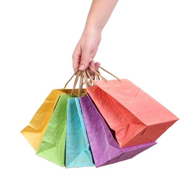 Kleurrijke boodschappentassen in vrouwelijke hand, geïsoleerd op wit — Stockfoto
