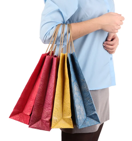 Mujer joven sosteniendo coloridas bolsas de compras en su mano, aisladas en blanco — Foto de Stock