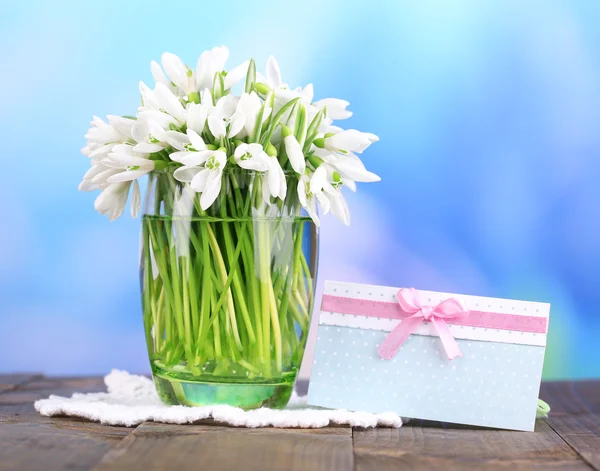 A váza, a fából készült asztal világos háttér gyönyörű hóvirág — Stock Fotó