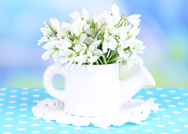 Beautiful snowdrops in vase, on table on bright background — Stock Photo, Image