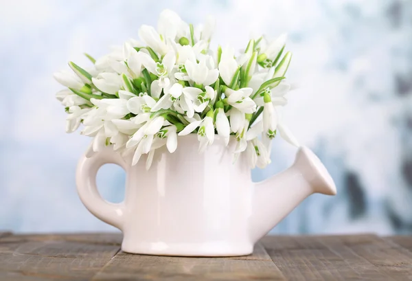 Beautiful snowdrops in vase, on table on bright background — Stock Photo, Image