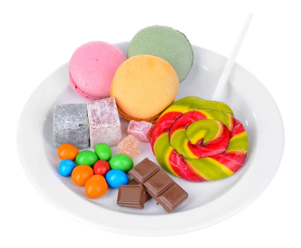 Różne słodycze na płytkę na białym tle — Zdjęcie stockowe