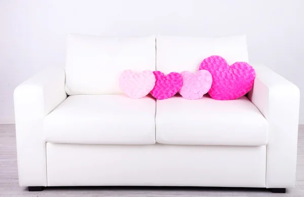 Růžové srdce ve tvaru polštáře na bílé pohovce — Stock fotografie