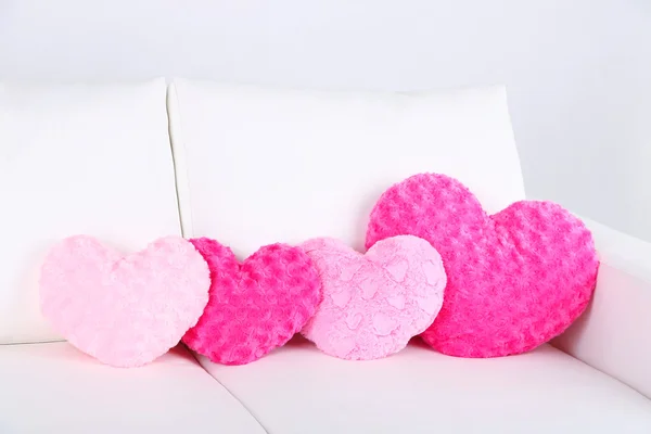 Pink heart shaped pillows on white sofa — Stock Photo, Image