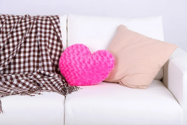 Almohadas en forma de corazón rosa en sofá blanco — Foto de Stock