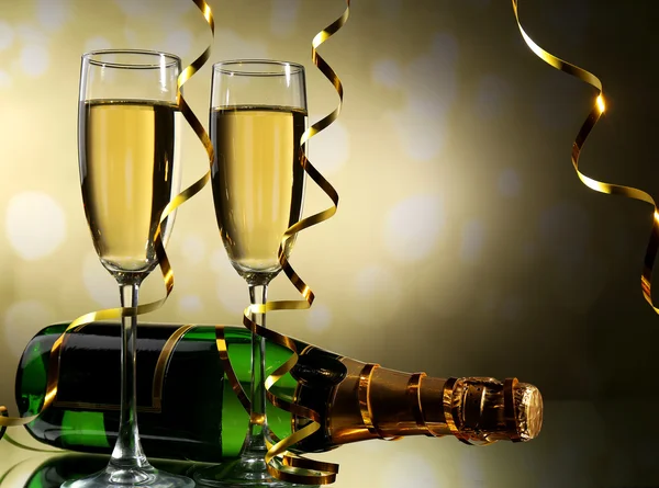 Copos e garrafa de champanhe no fundo claro — Fotografia de Stock