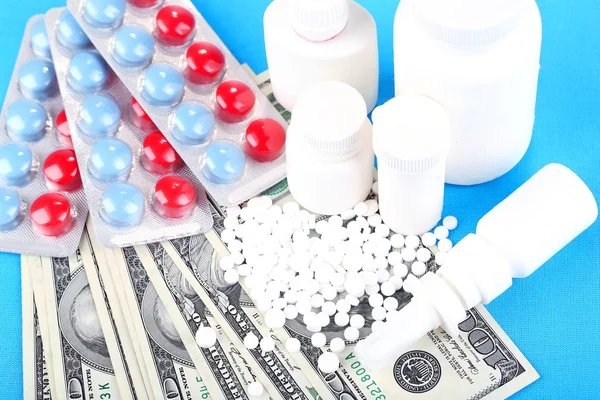 Prescription drugs on money background representing rising health care costs. On color background — Stock Photo, Image