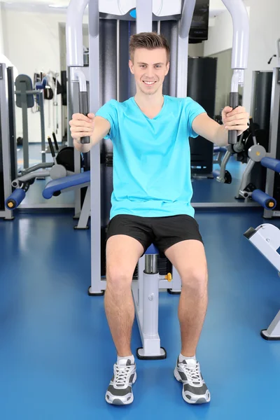 Young man training with weights in gym Stock Photo