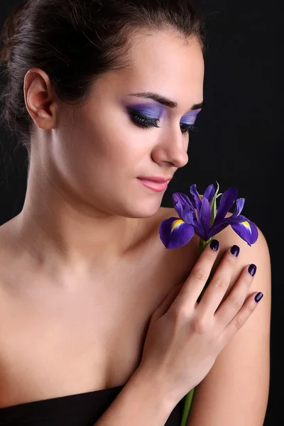 Hermosa joven con flor sobre fondo oscuro — Foto de Stock