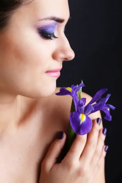 Красива молода жінка з квіткою на темному тлі — стокове фото