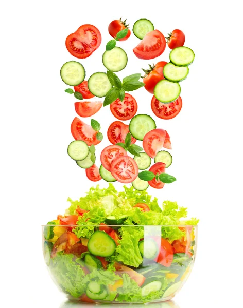 Fresh mixed vegetables falling into bowl of salad isolated on white Stock Image