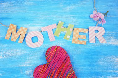 Anne-yazı mavi ahşap arka plan olarak el yapımı kağıt harflerin