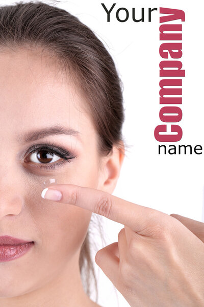 Young woman putting contact lens in her eye close up