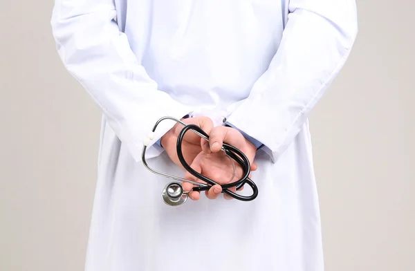 Αρσενικό Γιατρός στέκεται σε γκρι φόντο — Φωτογραφία Αρχείου