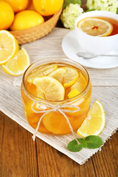 Tasty lemon jam with cup of tea on table close-up — Stock Photo, Image