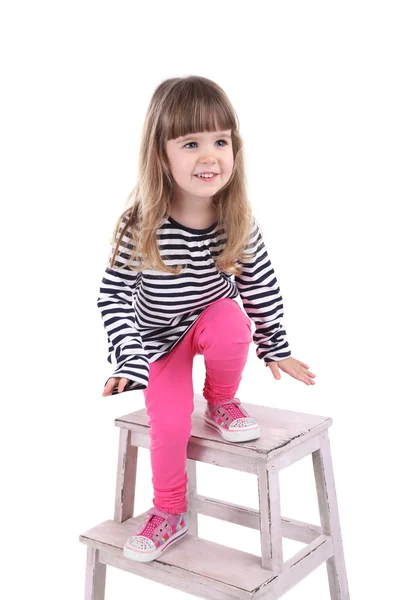Söt liten flicka sitter på liten stege isolerad på vit — Stockfoto