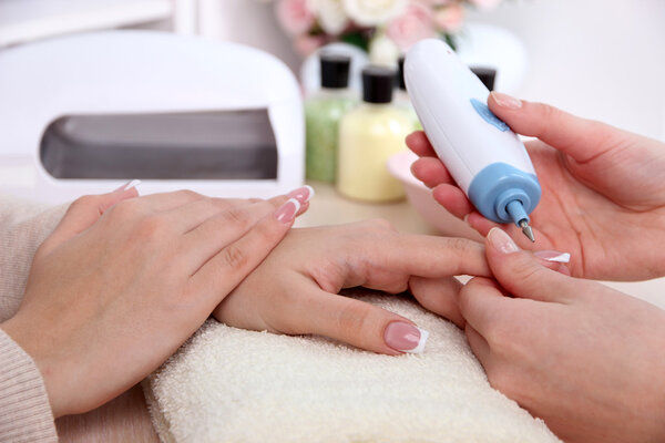 Manicure process in beauty salon close up