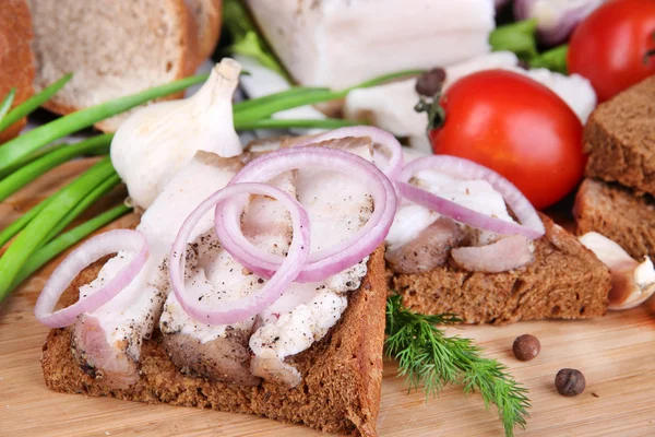 Sneetjes brood en reuzel met groenten op tafel close-up — Zdjęcie stockowe