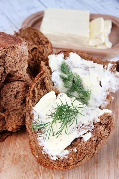 Rye bread with butter on cutting board close up — Stock Photo, Image
