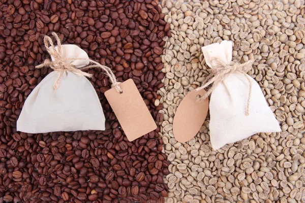 Sacchi con caffè su sfondo chicchi di caffè — Foto Stock