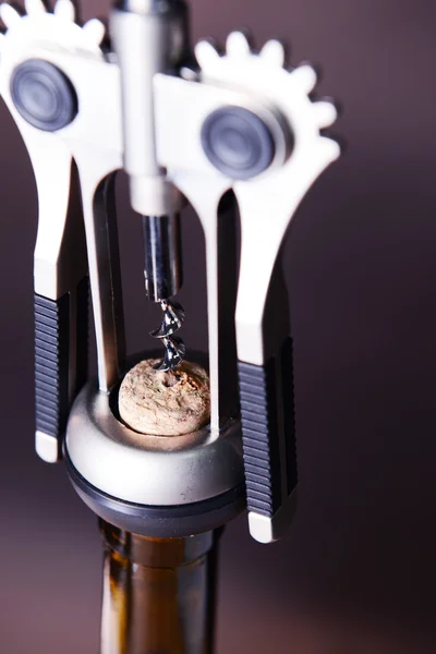 Corkscrew with bottle of wine on wooden background — Stock Photo, Image