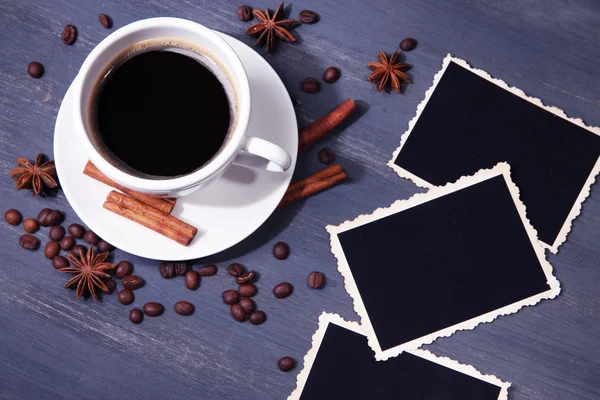 Koffiekopje en oude leeg foto's en specerijen, op houten achtergrond — Stockfoto