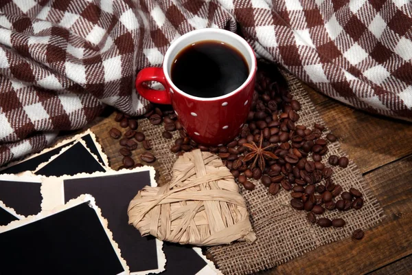 Samenstelling met koffiekopje, decoratieve harten, geruite kruiden en oude foto's in het lege, op houten achtergrond — Stockfoto