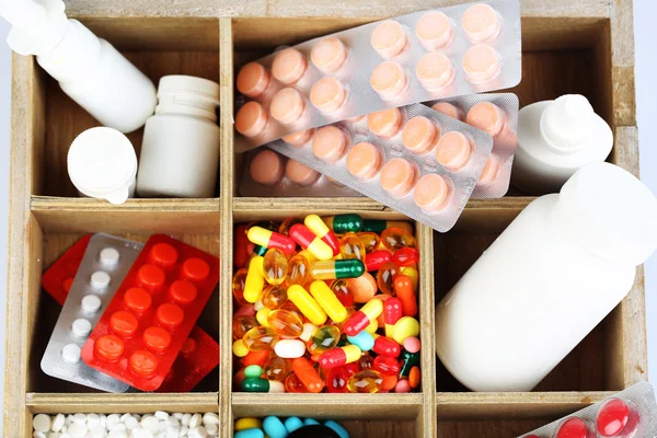 Medical pills, ampules in wooden box, close-up — Stock Photo, Image