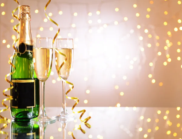 Очки и бутылка шампанского на блестящем фоне — стоковое фото