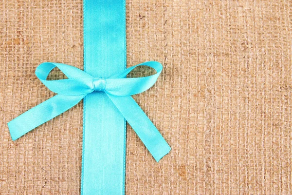 Sackcloth background with color ribbon and bow — Stock Photo, Image