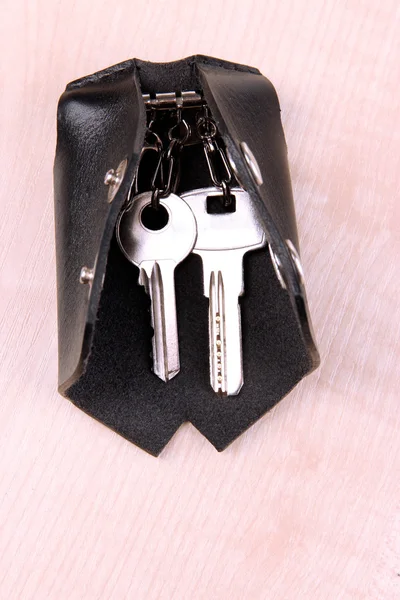 Caso chave de couro preto no fundo de madeira — Fotografia de Stock