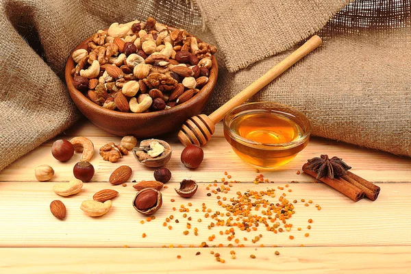 Солодкий мед і різні горіхи на дерев'яному столі — стокове фото
