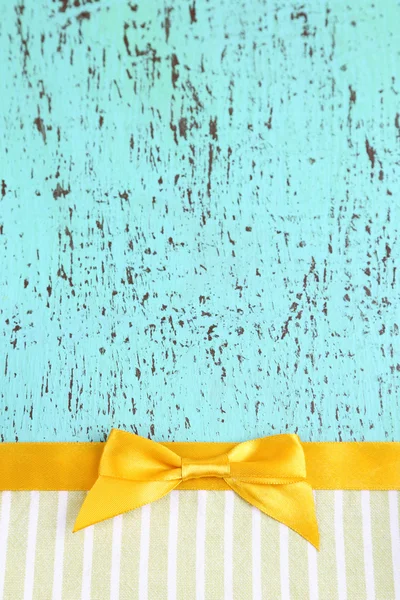 Barevné tkaniny s color ribbon a luk na dřevěné pozadí — Stock fotografie