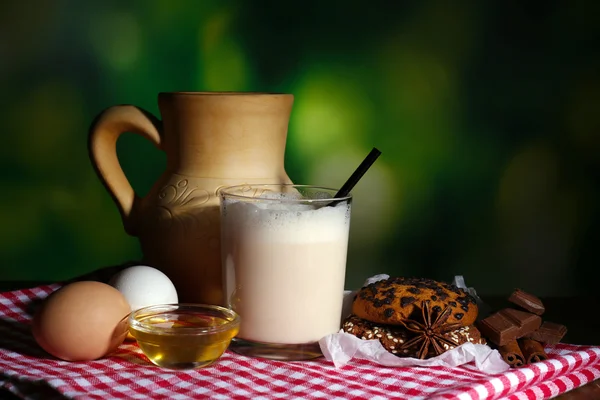 Eggnog with milk and eggs on tablecloth on natural background — Stock Photo, Image